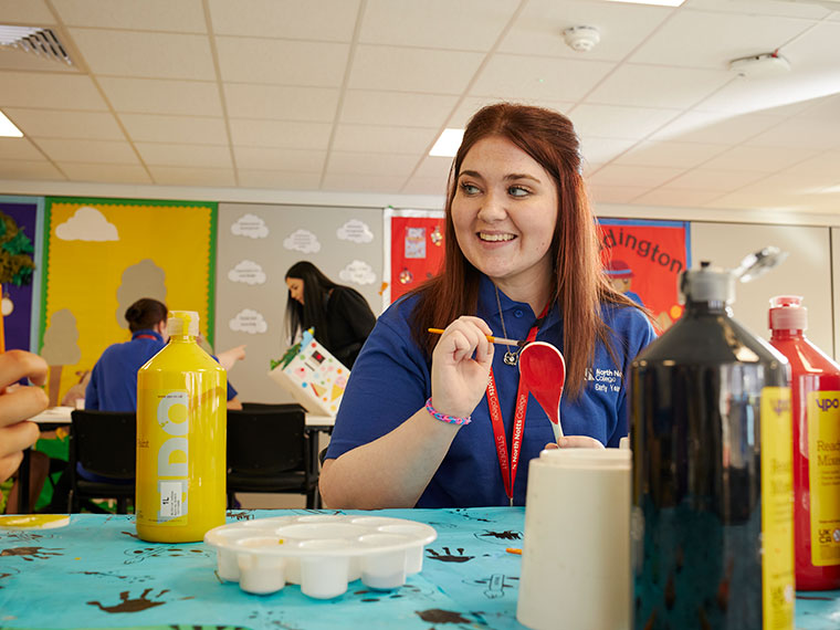 A student sat at a table painting