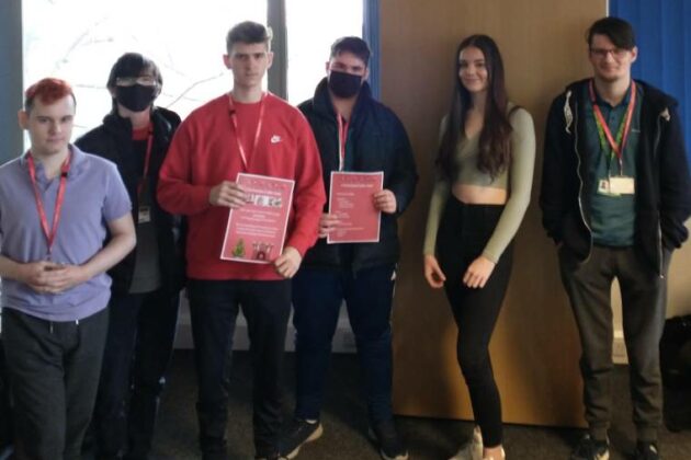 The Business students holding their poster showcasing their cake sale