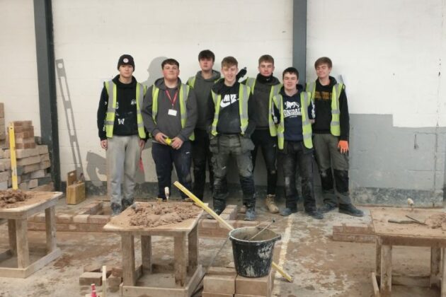 An image of the Construction students that competed in the inter-college competition stood in the workshop.