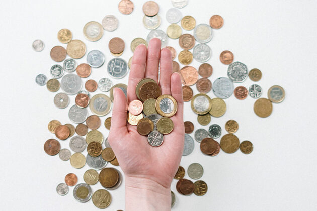 A hand holding coins