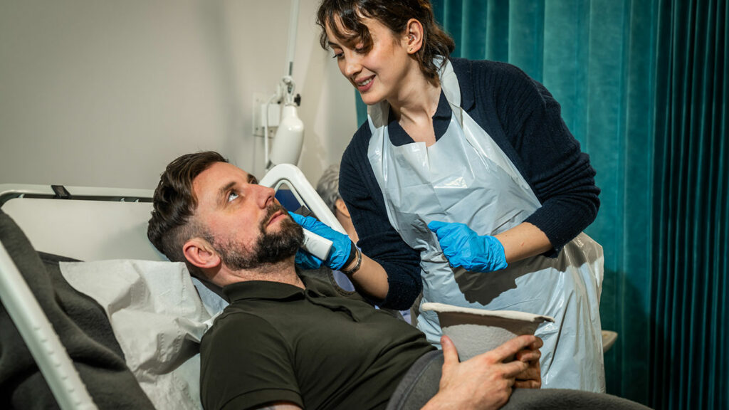 Healthcare student by a patient's bedside