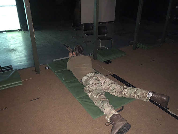 A Protective Services student laid on the floor at a shooting range