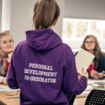 A Personal Development Coordinator talking to students