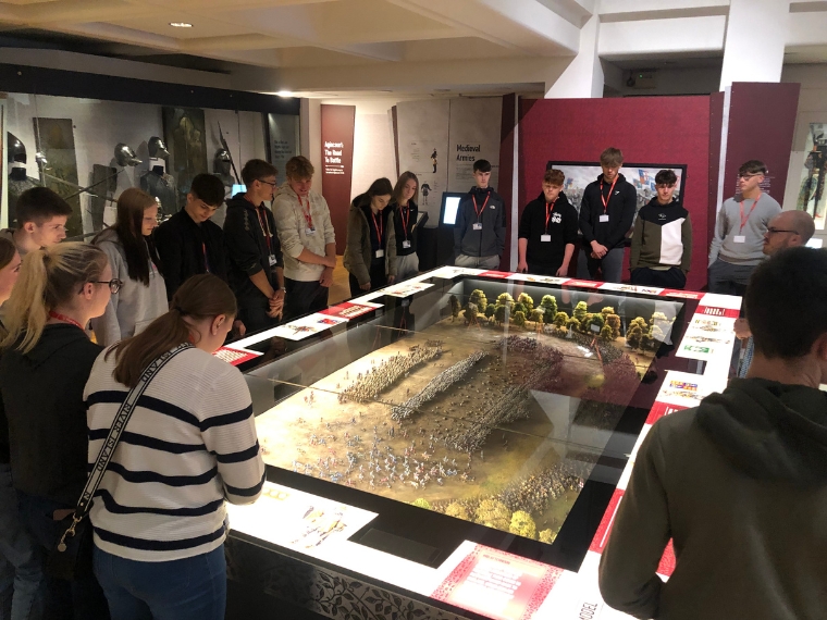 students gather round an exhibit