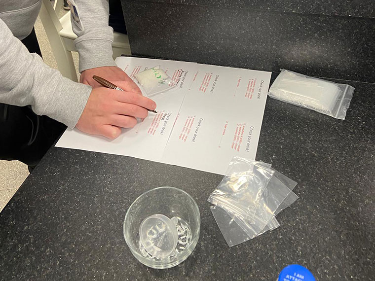 A student writing down results from the experiment