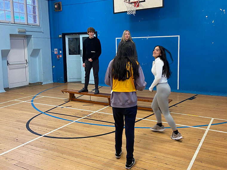 Students playing basketball in the sports hall