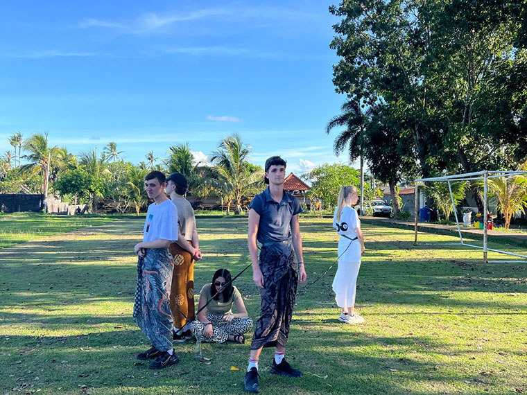 Students taking part in Indonesian games on grass under blue skies