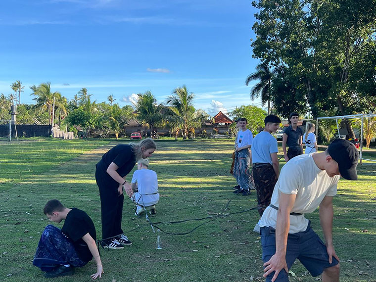 Students taking part in Indonesian games on grass under blue skies