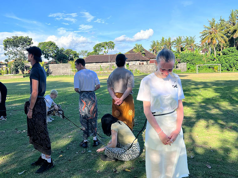Students taking part in Indonesian games on grass under blue skies