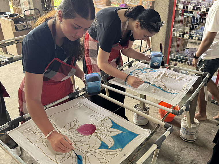 Two people each working on a print