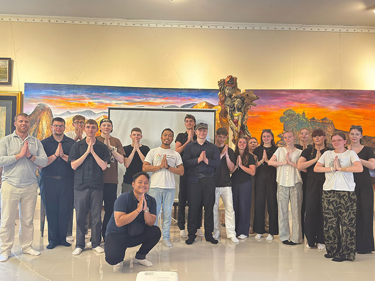 A group of people stood with their hands in prayer