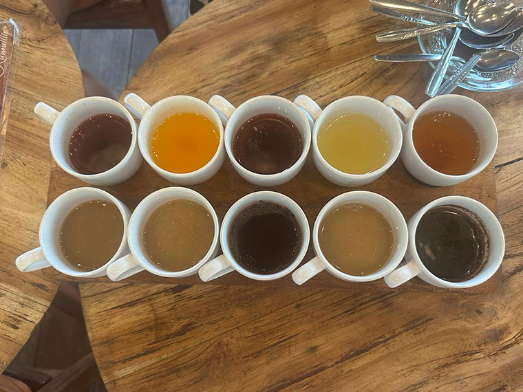 Looking down at ten cups of tea each a different colour