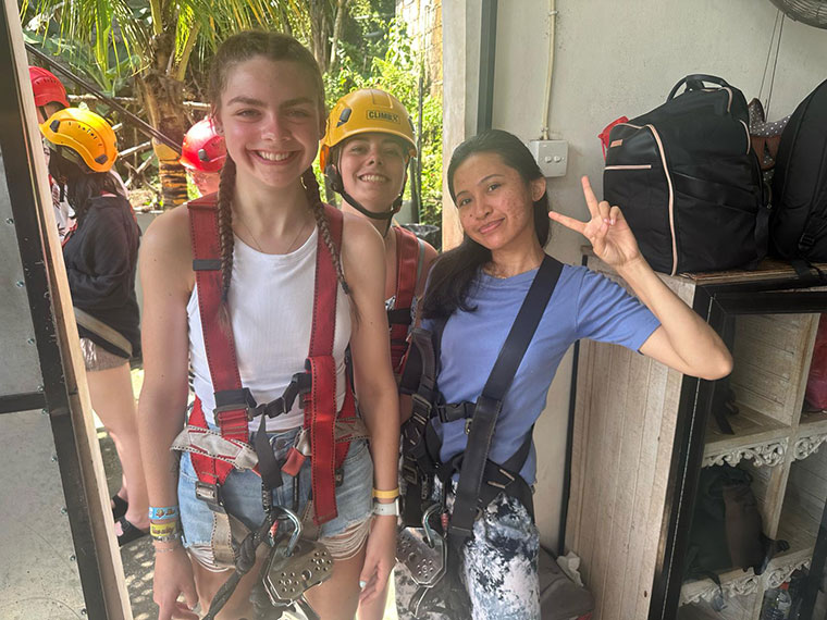 Three students in harnesses ready to take part in activities