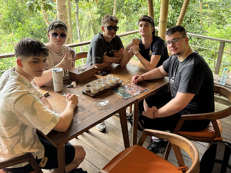 Five males sat at a table sampling Bali's local tea