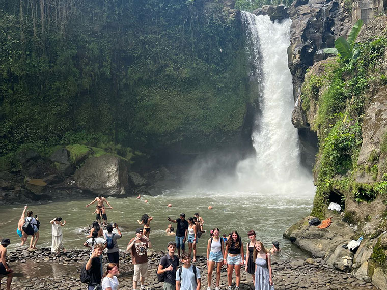 People stood in the foreground next to the Tegenungan Waterfall in Bali