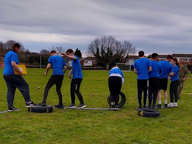 Students attempting an obstacle course on a field