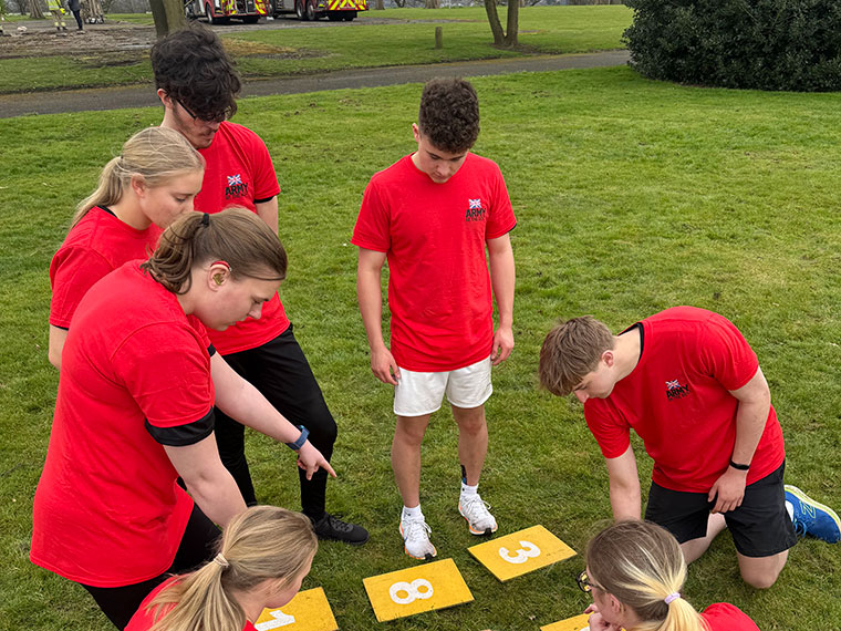 Students pointing to large numbers on the floor solving a puzzle