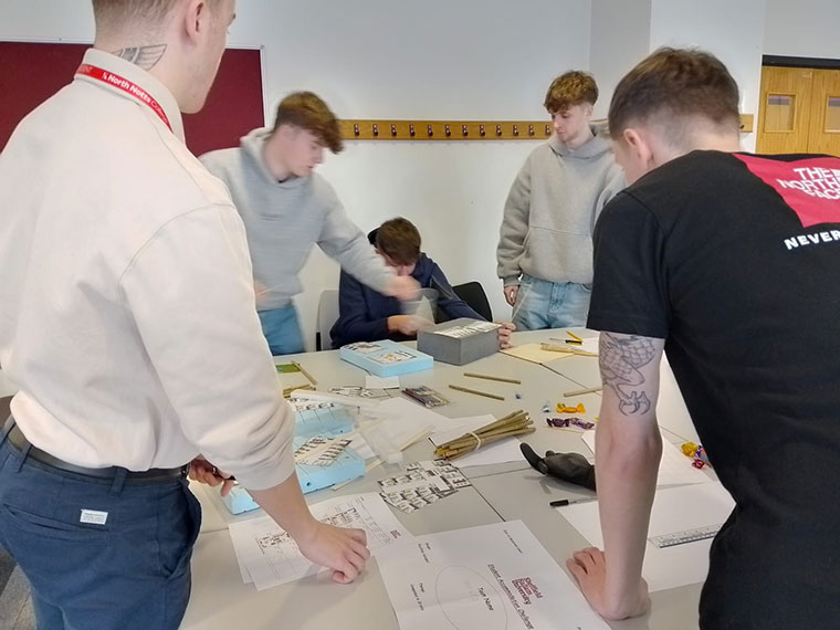 T Level students stood around a table working