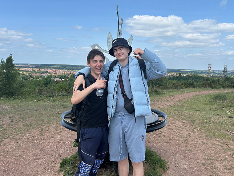 Two students stood together outside posing for a photo