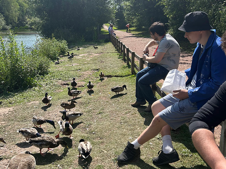 Feeding the ducks next to a pond