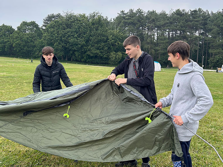 Students putting a tent up in a field