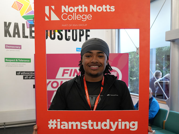 A smiling student holding a frame during welcome week 2025