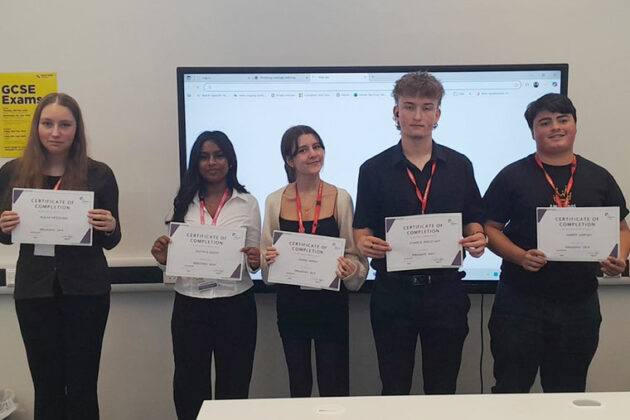 A group of students holding up their certificates