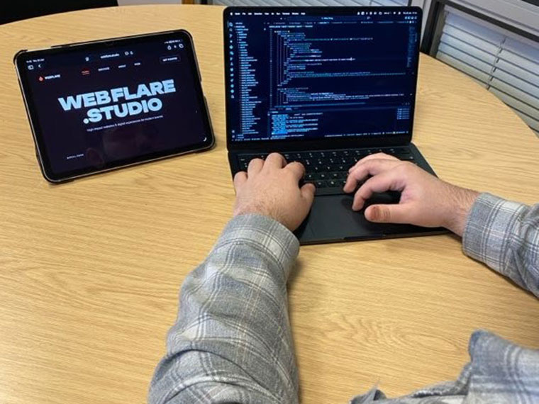 A student at a desk in front of a laptop and tablet