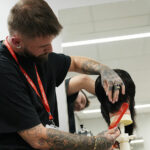An adult learner cutting hair in the College's training salon