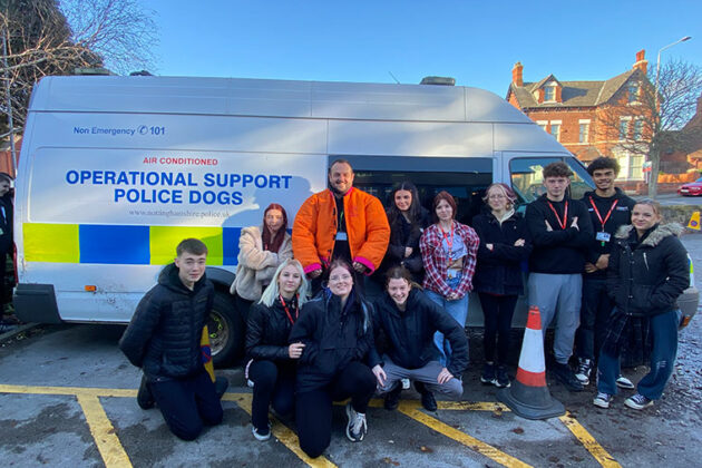 Protective Services students and two police dog handlers stood at the side of a police van