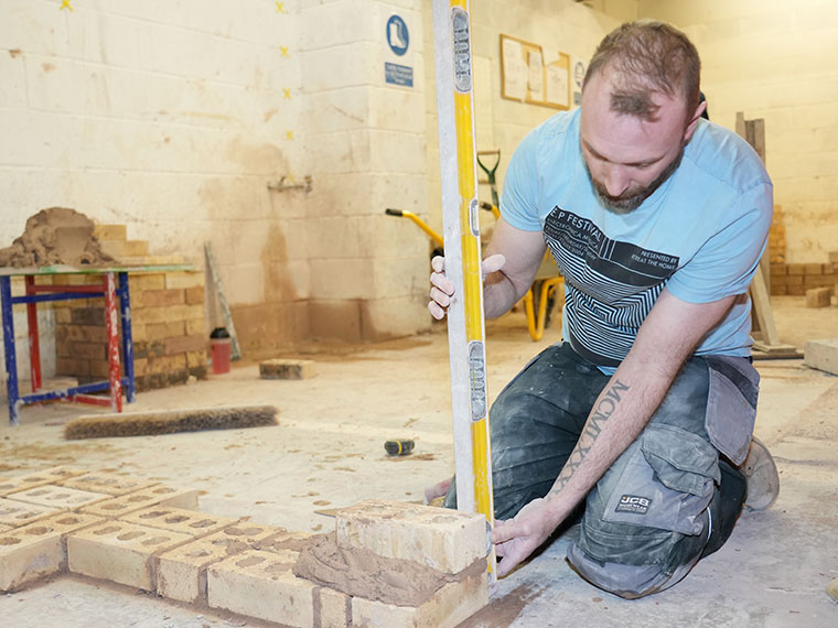 An adult bricklaying learner in the workshop