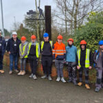 Students and staff stood in a line, some wearing high vis jackets