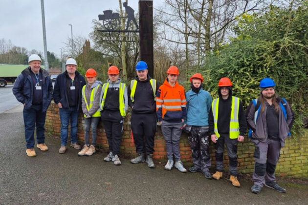 Students and staff stood in a line, some wearing high vis jackets