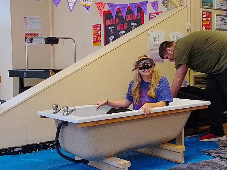 A member of staff preparing to be slimed on Wear it Purple day