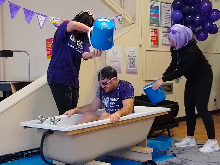 A member of staff being slimed on Wear it Purple day