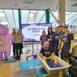Staff stood around the slime bath on Wear it Purple day