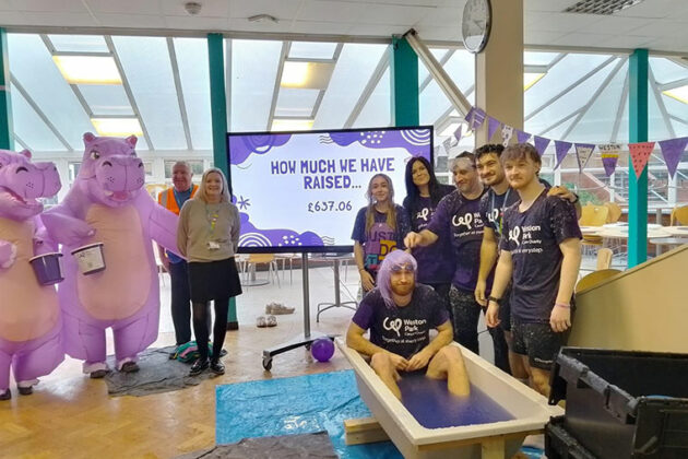 Staff stood around the slime bath on Wear it Purple day