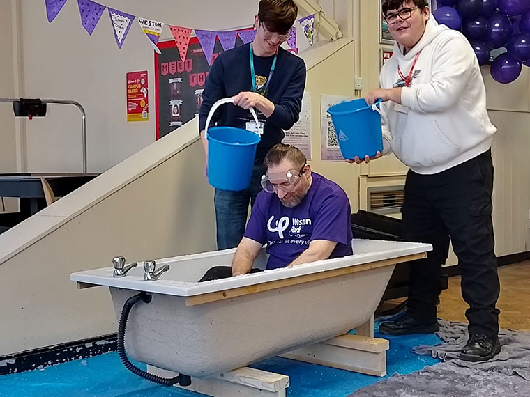 A member of staff being slimed on Wear it Purple day