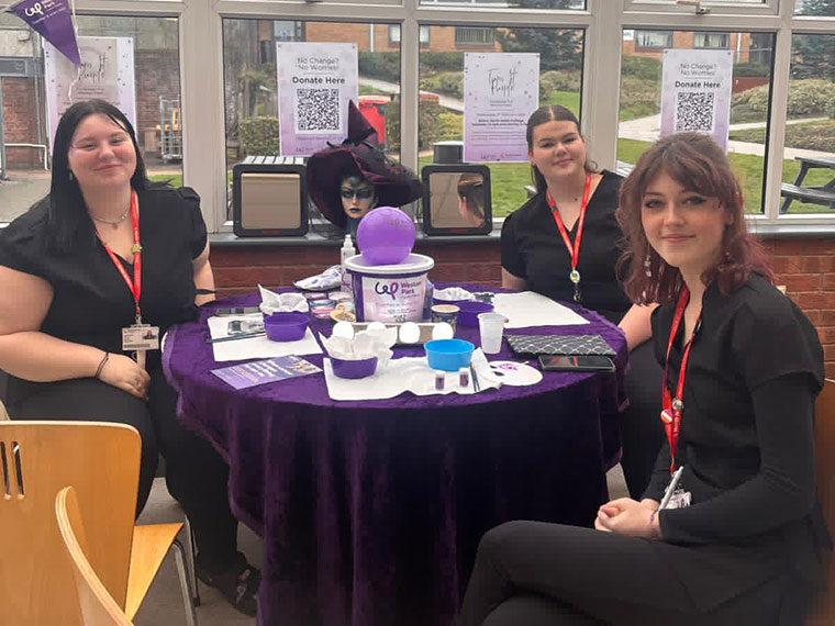 Students sat around a table raising money on World Cancer Day