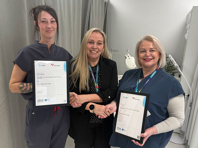 Level 4 Aesthetics student Jodie holding up her certificate, stood next to two members of staff