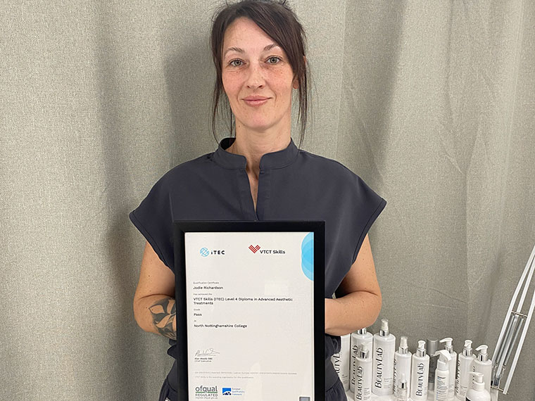 Level 4 Aesthetics student Jodie holding up her certificate