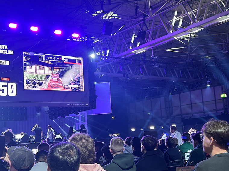 A large screen with an audience watching