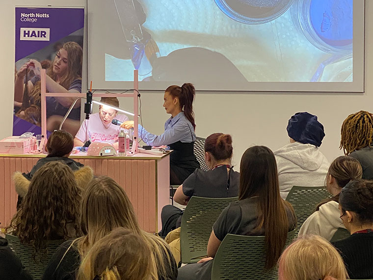 Two ladies demonstrating Glitterbels products in front of an audience
