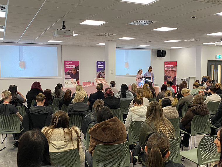 An audience sat looking towards the front of the room listening to someone speaking