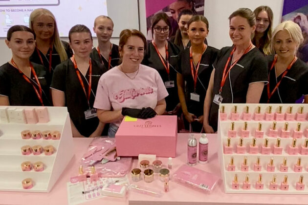A group of students stood with a lady demonstrating Glitterbels products