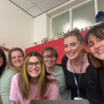 A group of six smiling people looking at the camera