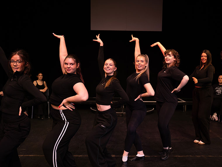 A group of performance students stood in a pose