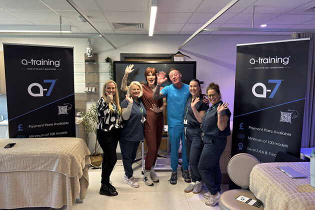 Six people stood together with two beauty therapy beds next to them and two a-training pull up banners