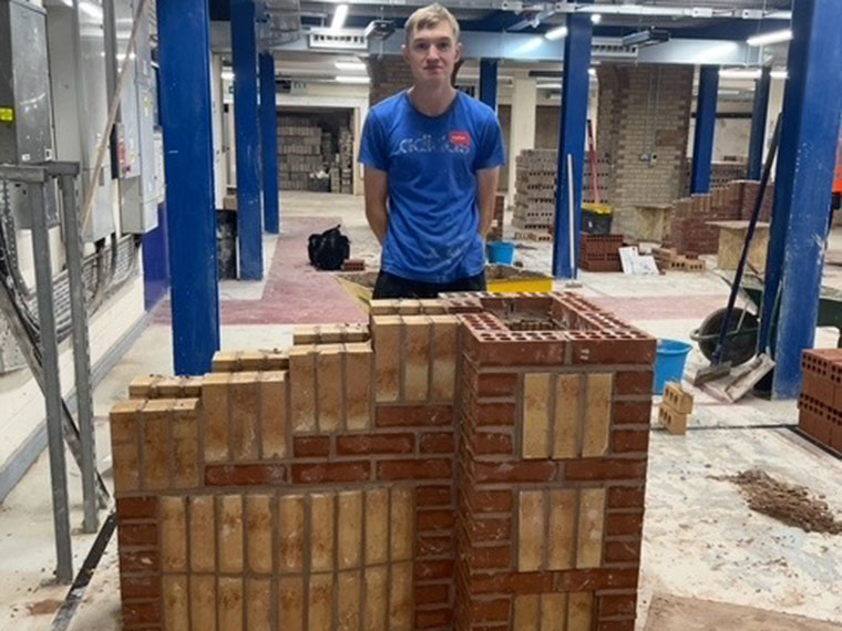Someone proudly stood behind a brick wall design