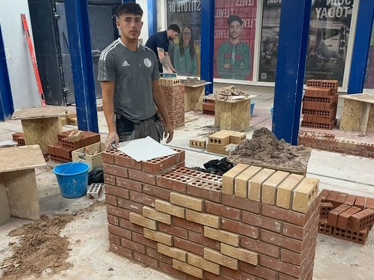 Someone proudly stood behind a brick wall design